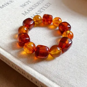 Close-up of amber acrylic beaded bracelet with irregular geometric shapes on a book.
