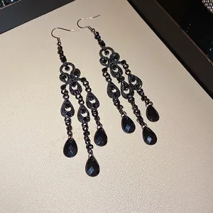 Detail view of black vintage chandelier earrings with faceted teardrop crystals in gothic style