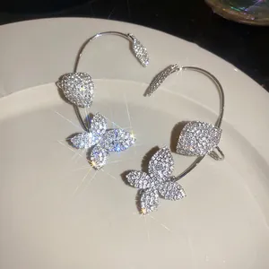 Primer plano de elegantes pendientes de flores con pedrería y efecto brillante