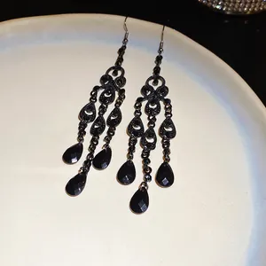 Detail of vintage black chandelier teardrop earrings with intricate hollow design