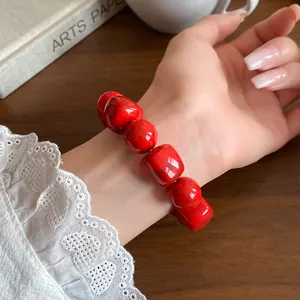 Detailed view of a vibrant red acrylic beaded bracelet with irregular geometric beads
