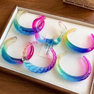 Detail view of colorful gradient resin open bangles with irregular geometric textures.
