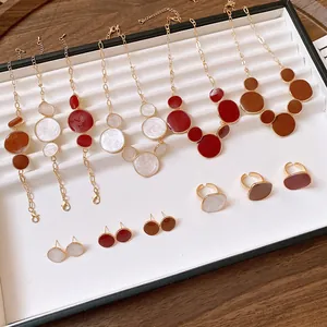 Retro jewelry collection with irregular circular pendants in cream, red, and brown.