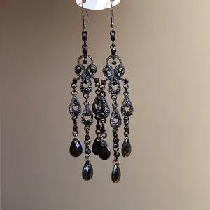 Vintage court style chandelier earrings with black teardrop rhinestones and hollow tassels.
