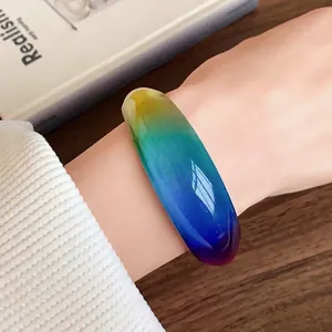 Close-up view of a colorful resin bangle featuring a vibrant gradient smudge effect