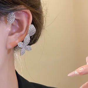 Vista detallada de una modelo con un elegante ear cuff de flores con pedrería brillante