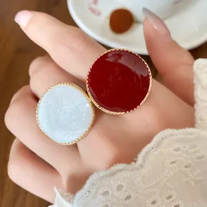 Close-up of vintage French style red and white enamel rings with gold beaded edges