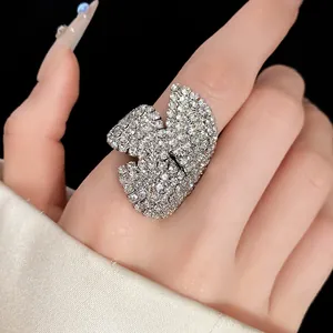 Anillo de flor con pedrería brillante en la mano con uñas largas y manicura elegante