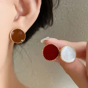 Close-up of vintage French style round stud earrings in red, brown, and white