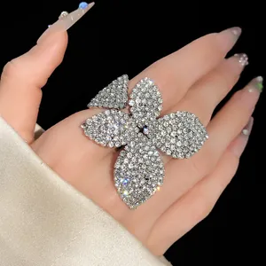 Primer plano de un anillo grande en forma de flor con brillantes pedrería.
