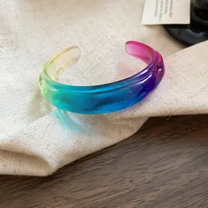 Close-up of colorful gradient resin cuff bracelet with irregular wavy geometric design
