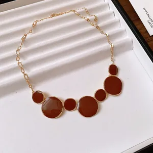 Elegant detail view of a French vintage necklace featuring reddish-brown circular pendants