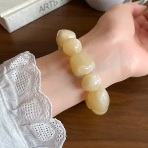 Close-up detail of a cream acrylic irregular geometric beaded bracelet on a wrist