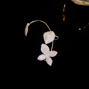 Detalle de un pendiente trepador de mariposa con brillantes diamantes de imitación
