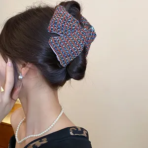 Close-up of a Korean style colorful tweed fabric hair claw clip worn on a bun for styling
