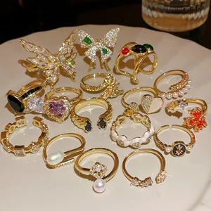 Detailed view of various gold plated zircon rings with butterfly and heart designs