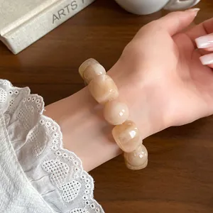 Close-up view of an acrylic irregular geometric beaded bracelet on a woman's wrist.