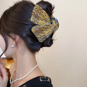 Side view of an elegant Korean style tweed bow hair claw clip styled on brunette hair