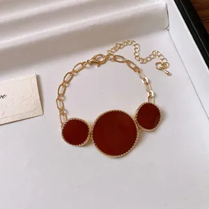 Detailed view of French vintage necklace with burgundy circular pendants on gold chain