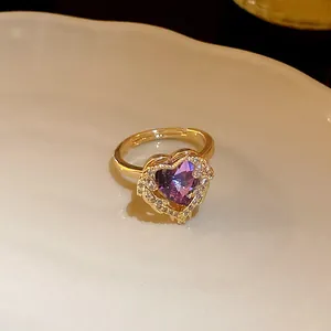 Close-up of a gold-plated adjustable ring featuring a sparkling purple heart zircon.