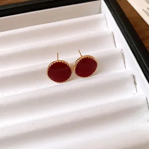 Elegant red enamel round stud earrings with gold scalloped border in a white jewelry box