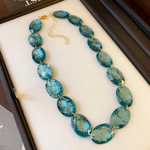 Detailed view of retro oval teal resin beads on a minimalist gold-tone adjustable necklace.