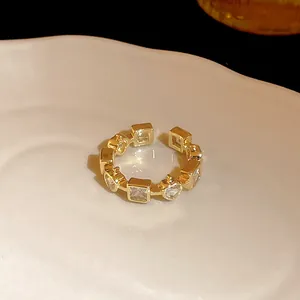 Detailed view of a luxury gold-plated open ring with heart and square zircon accents