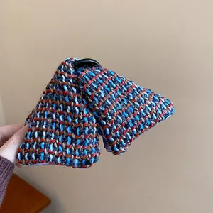Close-up of triangular hair claw clip with multi-color woven tweed fabric texture.