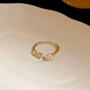 Detailed view of the delicate pink flower and zircon arrangement on a gold open ring