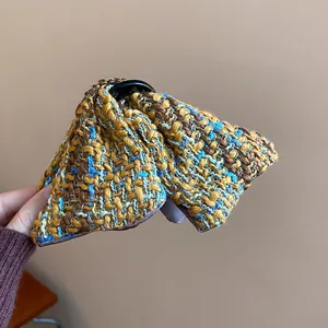 Macro view showing the intricate woven plaid texture of the fabric hair claw clip.