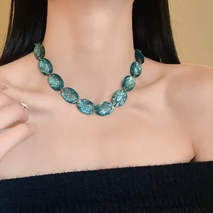 Close-up detail of retro emerald green oval resin necklace worn by a female model