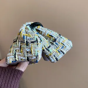 Close-up detail of a Korean style tweed plaid hair claw clip with colorful weave texture