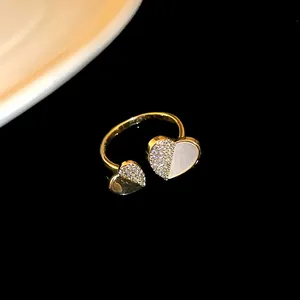 Detailed macro view of a gold plated adjustable ring with zircon paved hearts and white shell inlay