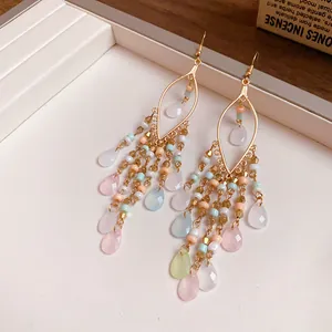 Detail view of bohemian tassel earrings with colorful beads and teardrop stones.