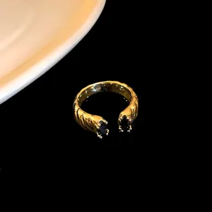 Close-up of luxury gold plated dragon textured open ring featuring black oval zircon stones
