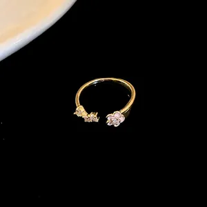 Close-up detail of a delicate gold plated open ring featuring pink flowers and zircons