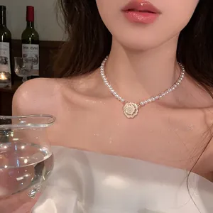 Collier ras du cou élégant en perles blanches avec un pendentif rose délicat sur un mannequin