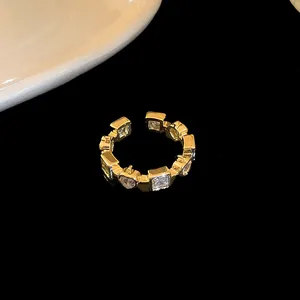 Close-up of gold plated open ring with heart and square cubic zirconia stones