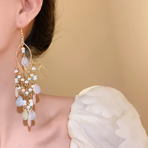 Close-up detail of Bohemian beaded tassel earrings featuring elegant translucent teardrop pendants.