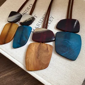 Macro view of irregular resin horn pendants with unique marble patterns on canvas book