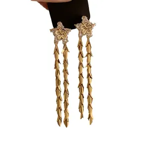Eleganti orecchini a stella in zircone con lunghe nappe su uno sfondo bianco