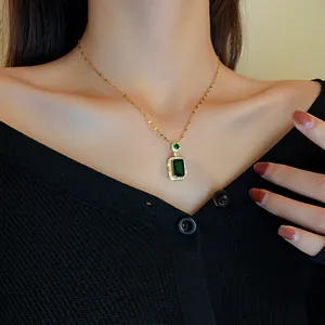 Close-up view of a vintage emerald green square pendant necklace with sparkling diamonds.