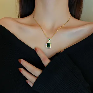Vintage rectangular emerald pendant necklace with crystal halo on black top