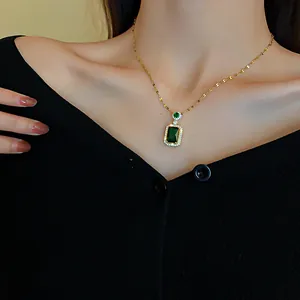 Close-up of a vintage-style emerald green rectangular pendant necklace with sparkling crystals.
