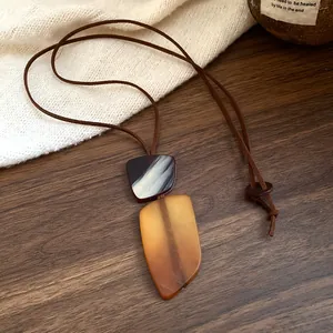 Close-up of irregular resin pendant necklace with vintage brown cord
