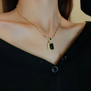 Detailed view of vintage emerald green square pendant necklace on dainty gold chain