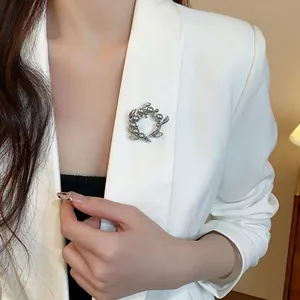 Élégante broche fleur en perles et zircons plaqué or sur revers de blazer blanc