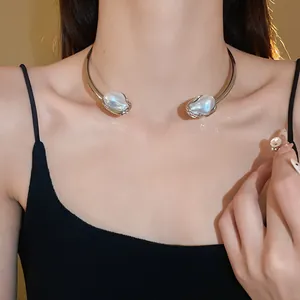 Close-up of a vintage-style gold choker featuring two irregular artificial baroque pearls.