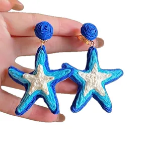 Handmade woven starfish drop earrings in vibrant blue and white, perfect for summer vacations.