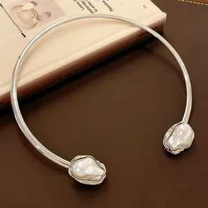 Detailed macro view of a vintage silver choker necklace with large irregular pearls